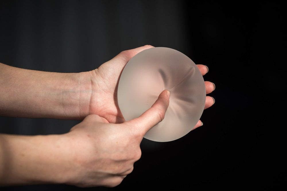 persona sostiene implantes mamarios de gel