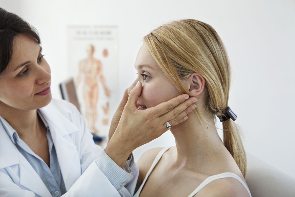 Una doctora revisa la nariz de us paciente después de hacer una rinomodelación