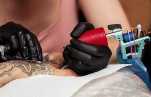 Mujer realiza un tatuaje en mano