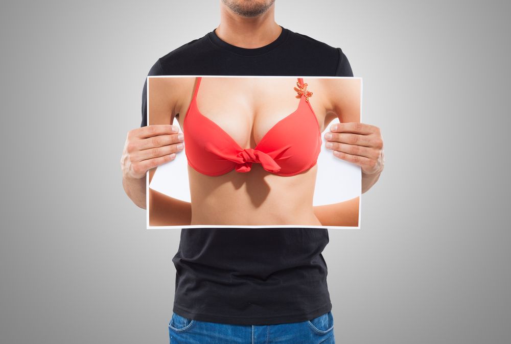 hombre con poster de pechos femeninos