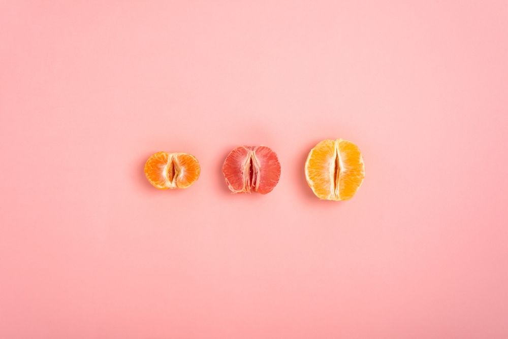 Tras mandarinas de diferente tamaño en fondo rosa