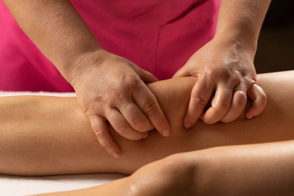 médico estético hace un masaje reductor en los muslos