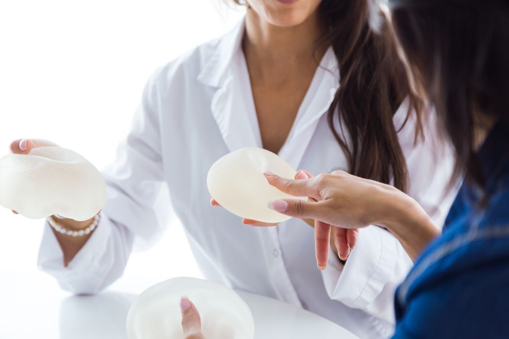 médico sostiene implantes mamarios