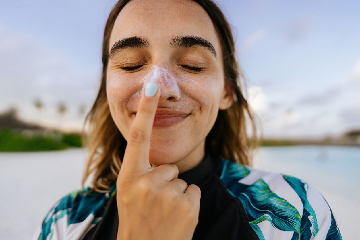 Mujer con protector solar en nariz